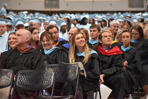 james clemens faculty amid graduates in their caps and gowns